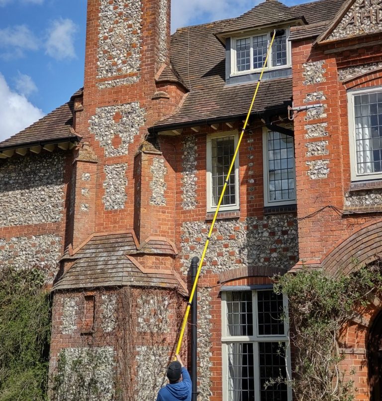 MJF Window Cleaning using a long pole to clean a window on a multi-storey house.