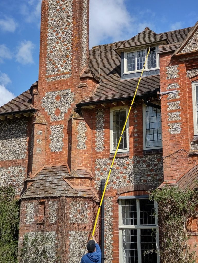MJF Window Cleaning.  Professional window cleaners. Cleaning a high window with our pure water fed pole. 