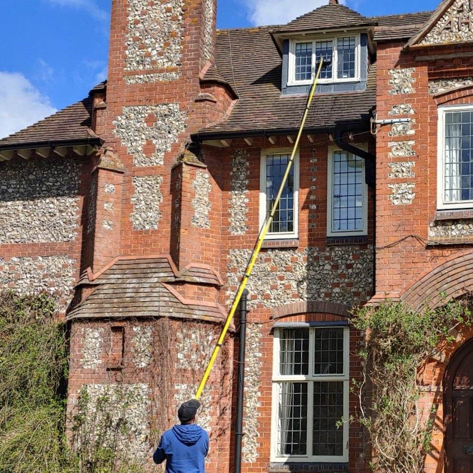 MJF Window Cleaning.  Professional window cleaners. Cleaning a high window with our pure water fed pole. 