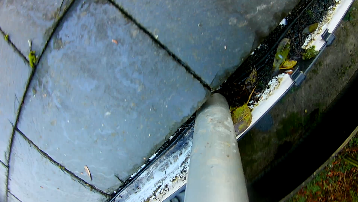 Close-up of a gutter being cleaned with our gutter vacuum system, removing debris from the gutter.  MJF Window Cleaning working in Bucks.